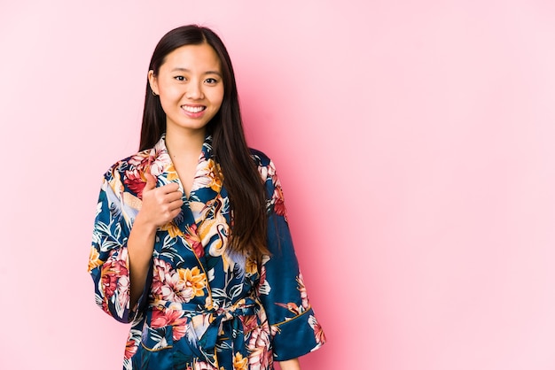 Jeune femme chinoise portant un pyjama kimono isolé souriant et levant le pouce vers le haut