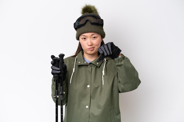 Jeune femme chinoise portant une veste d'hiver isolée sur fond blanc montrant le pouce vers le bas avec une expression négative