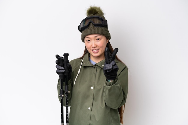 Jeune femme chinoise portant une veste d'hiver isolée sur fond blanc souriant et montrant le signe de la victoire