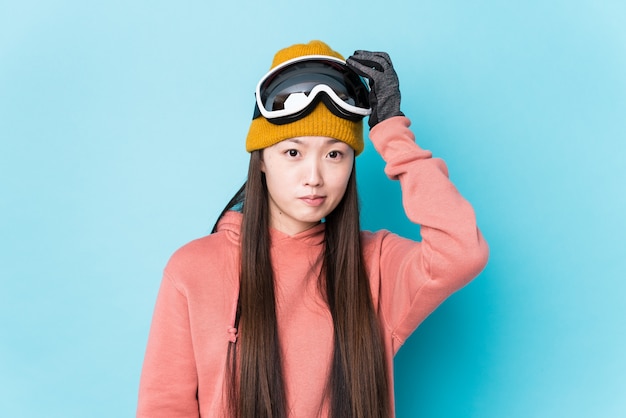 Une jeune femme chinoise portant des vêtements de ski isolés étant choquée, elle se souvient d'une rencontre importante.