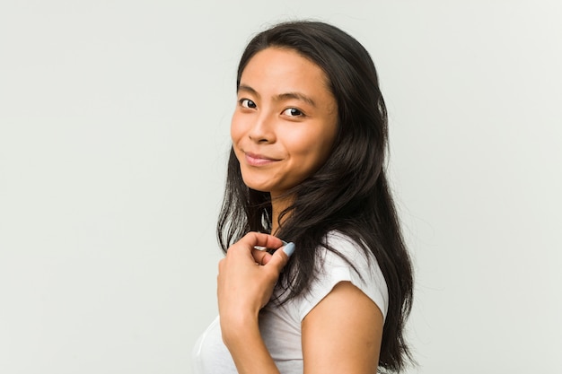 Jeune femme chinoise posant sur un mur blanc