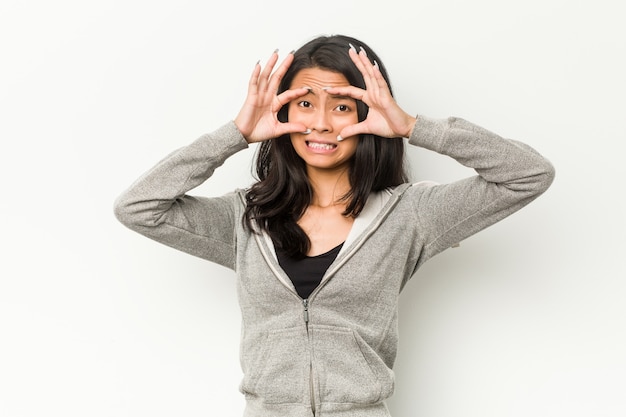 Jeune femme chinoise de remise en forme en gardant les yeux ouverts pour trouver une opportunité de réussite.