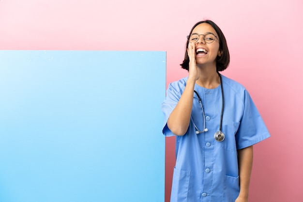 Jeune femme de chirurgien métisse avec une grande bannière sur fond isolé en criant avec la bouche grande ouverte