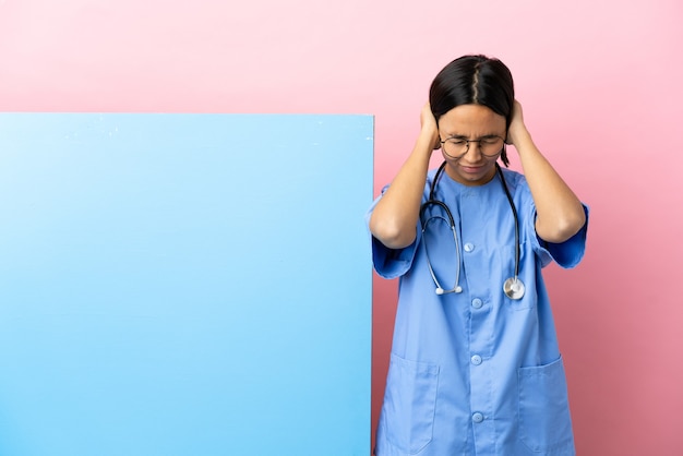 Jeune femme de chirurgien métisse avec une grande bannière sur fond isolé frustré et couvrant les oreilles