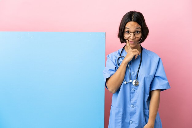 Jeune femme de chirurgien métisse avec une grande bannière sur fond isolé et de la pensée