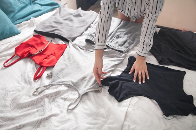 Jeune femme choisissant des vêtements à la maison.