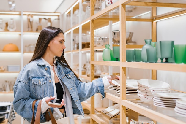 Une jeune femme choisit de la vaisselle dans un magasin de rénovation domestique