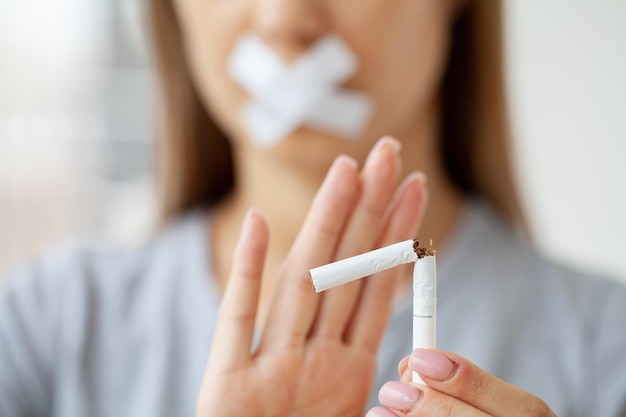 Jeune femme avec une cigarette cassée, arrêtez de fumer.