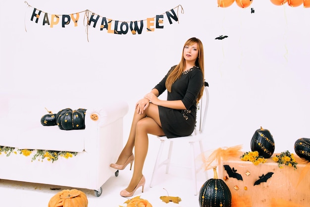 Jeune femme à la citrouille noire en décoration d'Halloween