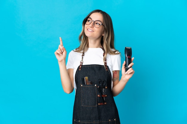 Jeune femme de coiffeur roumain isolée sur un mur bleu pointant vers le haut une excellente idée