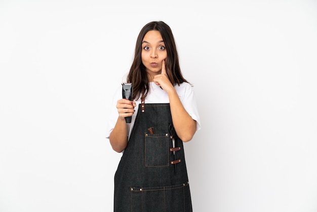 Jeune femme coiffeuse isolée sur mur blanc et à l'avant