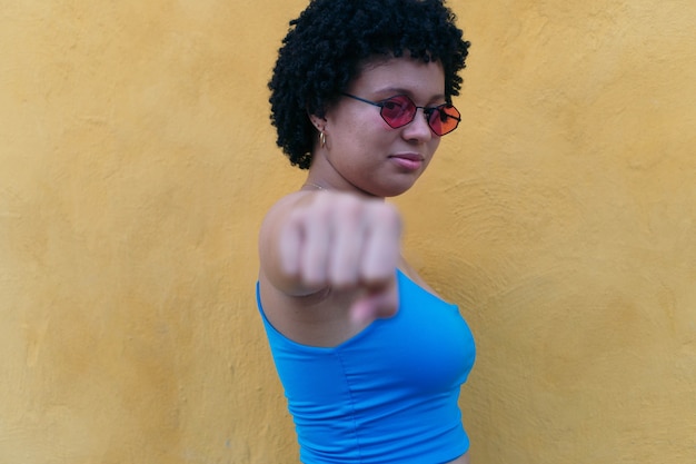 Jeune femme de coiffure afro avec des lunettes de soleil