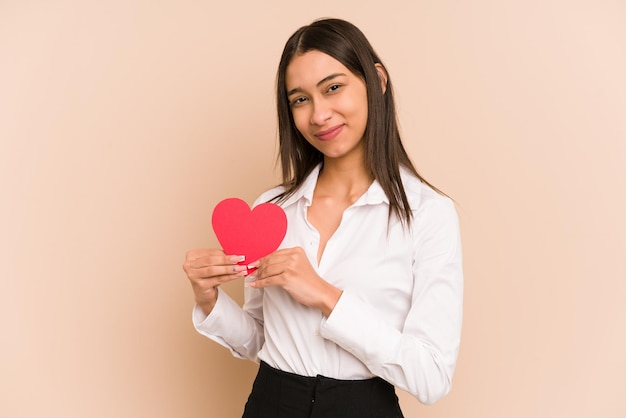 Jeune femme colombienne tenant un papier coeur pour la saint valentin isolé