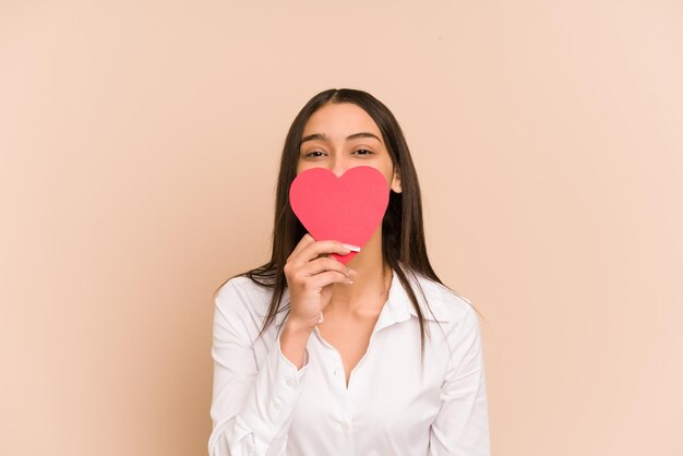Jeune femme colombienne tenant un papier coeur pour la saint valentin isolé