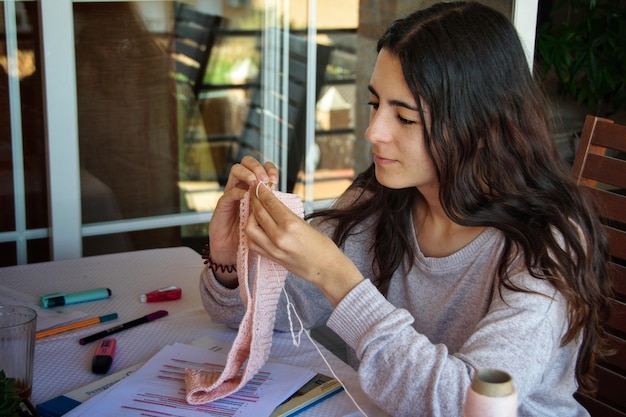 Jeune femme concentrée au crochet.