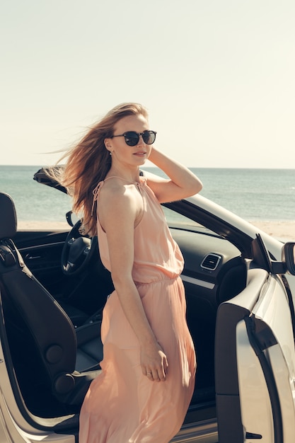 Jeune femme conduire une voiture sur la plage