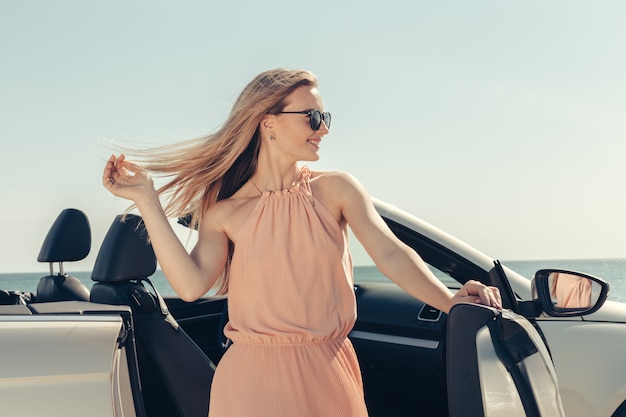 Jeune femme conduire une voiture sur la plage