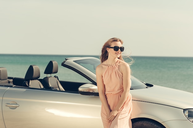 Jeune femme conduire une voiture sur la plage