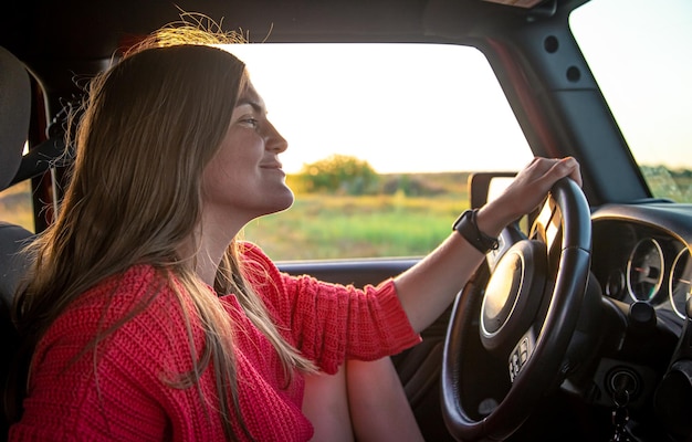 Une jeune femme conduisant un suv à la campagne