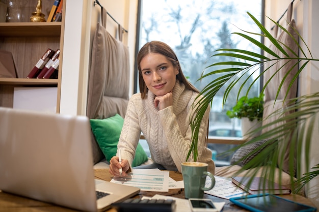 Une jeune femme confiante faisant la comptabilité de son entreprise