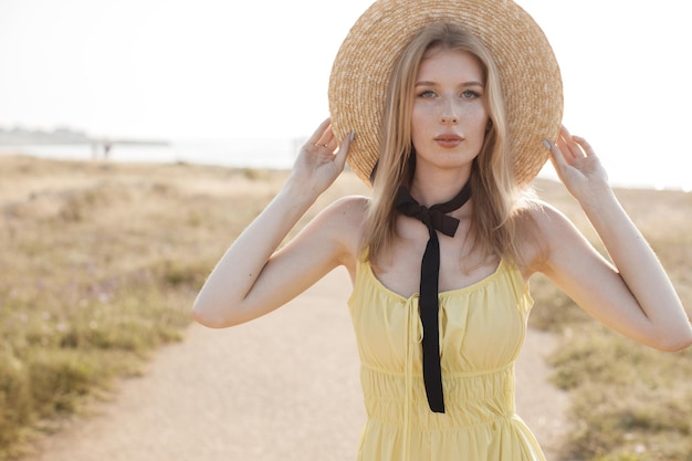 jeune femme confortable avec un chapeau dans le champ