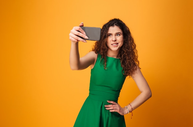 Jeune femme confuse faire selfie par téléphone mobile.