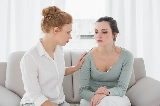 Jeune femme consolant une amie à la maison