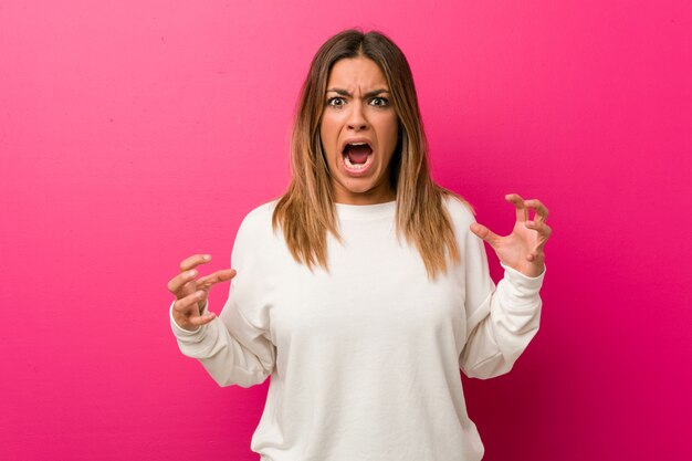 Jeune femme contre un mur hurlant de rage