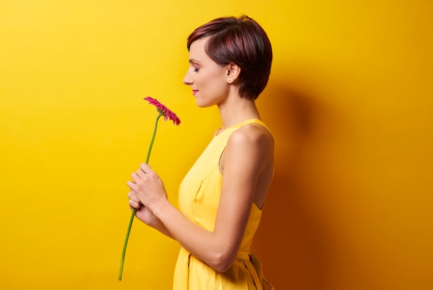 Jeune femme contre le mur jaune