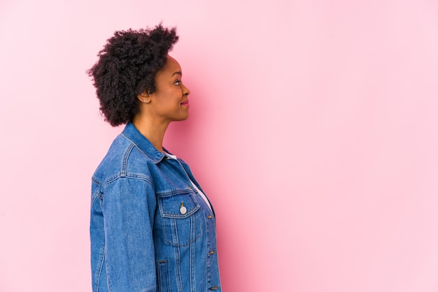 Jeune, femme, contre, rose, backgroound, isolé, regarder, gauche, côté, pose