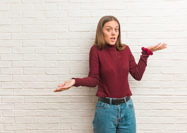 Jeune femme cool sur un mur de briques confus et douteux