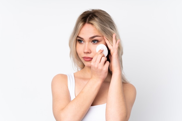 Jeune femme avec des cosmétiques sur un mur isolé