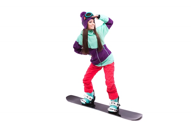 Jeune femme en costume de ski violet ride snowboard