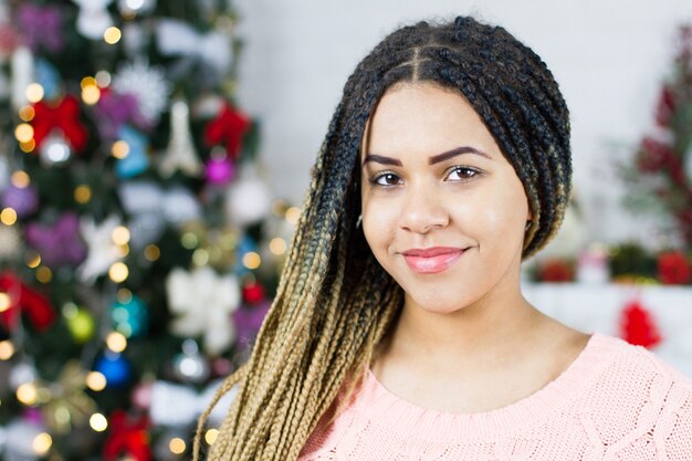 Jeune femme à côté de l'arbre de Noël