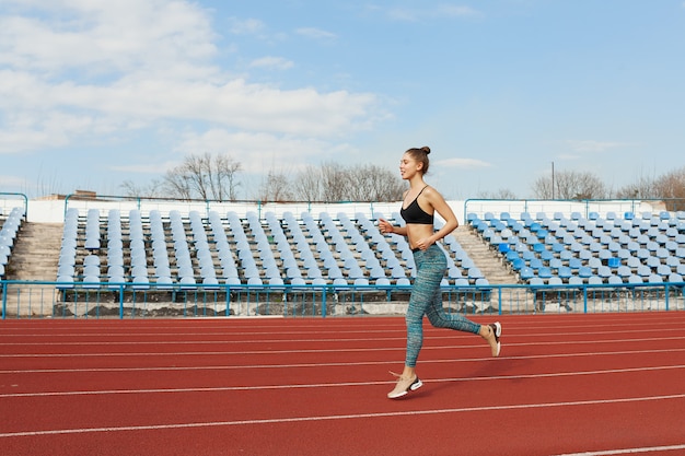 Jeune, femme, courant, ensoleillé, matin, stade, piste