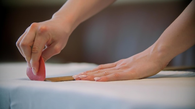 Jeune femme couturière faisant des marques à l'aide du savon sur le tissu