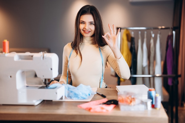 Jeune femme couturière avec machine à coudre