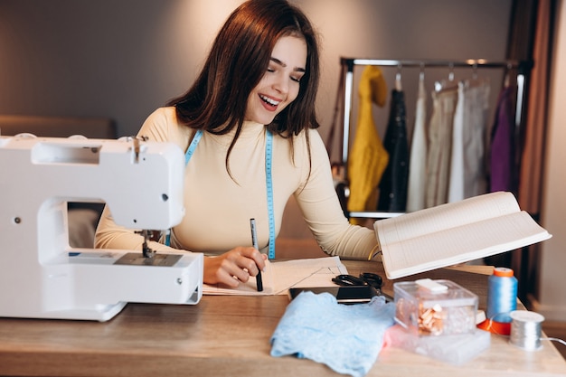 Jeune femme couturière avec machine à coudre