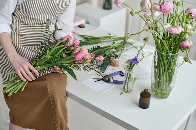 Jeune femme créative dans un magasin de fleurs avec un bouquet dans les mains Un démarrage d'entreprise de fleuriste