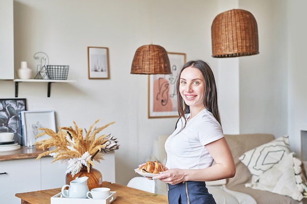 Jeune femme cuisinant dans la cuisine. Nourriture saine. Régime de remise en forme. Intérieur de cuisine clair. Fille souriante à la caméra. Portrait de femme au foyer.