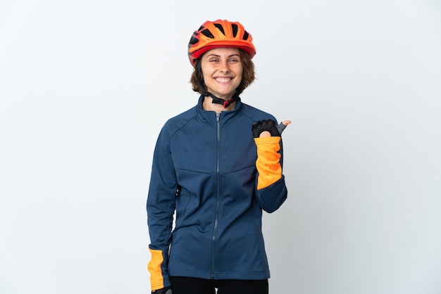 Jeune femme cycliste anglaise isolée sur un espace blanc pointant vers le côté pour présenter un produit