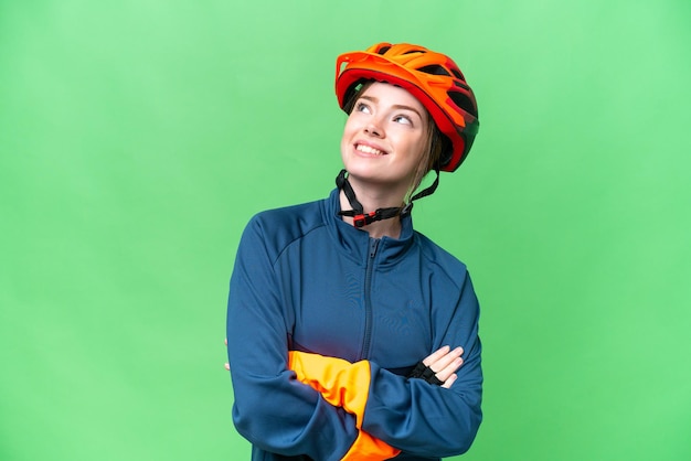 Jeune femme cycliste sur fond isolé chroma key regardant en souriant