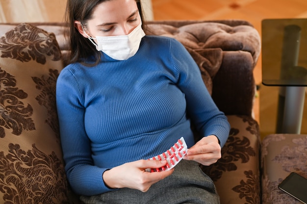 Jeune femme dans un bandage prend des pilules