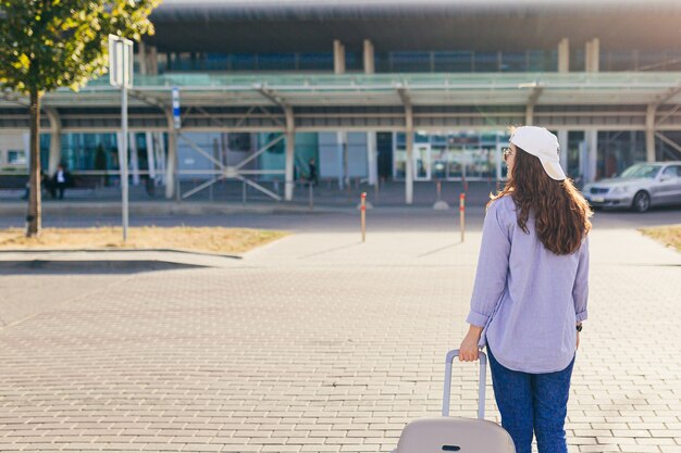 Jeune femme dans un bonnet blanc avec une valise