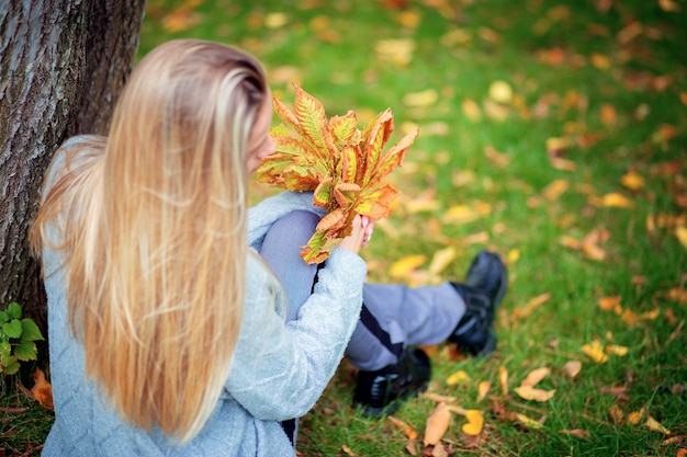 Jeune femme dans un cardigan gris dans le parc de l'automne