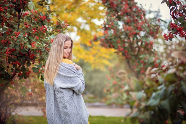 Jeune femme dans un cardigan gris dans le parc de l'automne