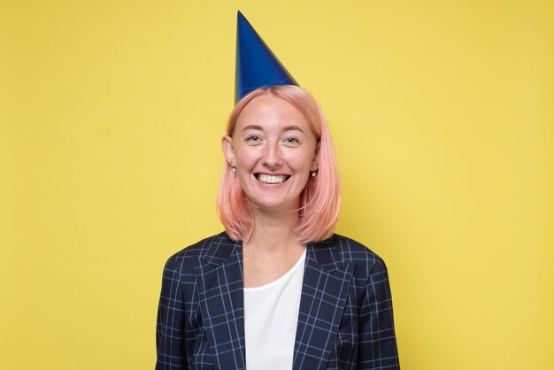 Jeune femme dans une casquette de fête souriant à la caméra lors d'une fête