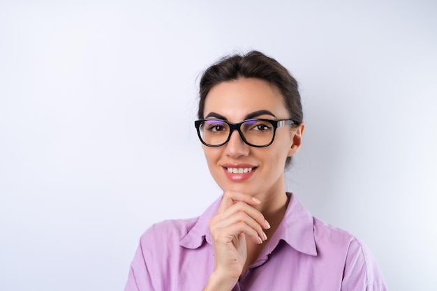 Jeune femme dans une chemise lilas sur fond blanc dans des verres pour une vision joyeuse positive de bonne humeur