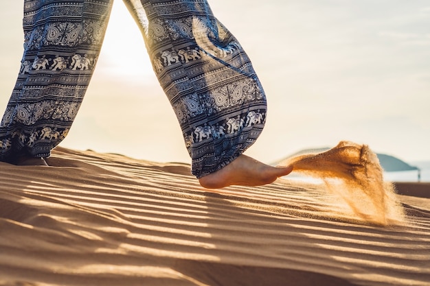 Jeune femme dans le désert de sable rad au coucher du soleil