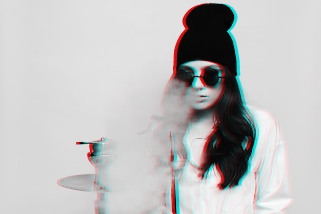 Photo une jeune femme dans une image de hipster fume une chicha de narguilé et aime fumer noir et blanc avec effet de réalité virtuelle glitch 3d